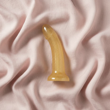 Gold sparkle dildo on blush pink linen